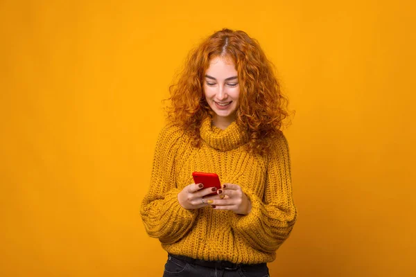 Foto de jovem mulher ruiva alegre usando seu smartphone sobre — Fotografia de Stock