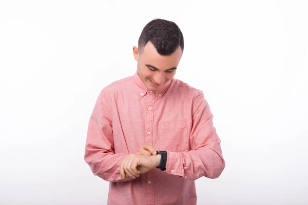 Joyeux bel homme utilisant smartwatch sur fond blanc — Photo