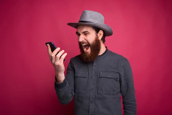 Photo of angry bearded man tallking on smartphone — Stock Photo, Image