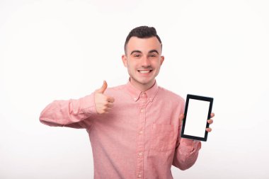 Kırmızı tişörtlü neşeli bir gencin fotoğrafı. Tablette başparmaklar yukarı ve boş ekran gösteriyor.