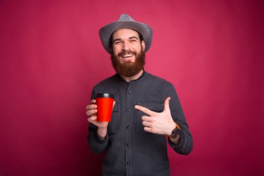 Genç adam taze kahveyi işaret ediyor.