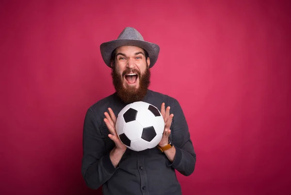 Erstaunt bärtiger Mann hält Fußballball und schreit — Stockfoto