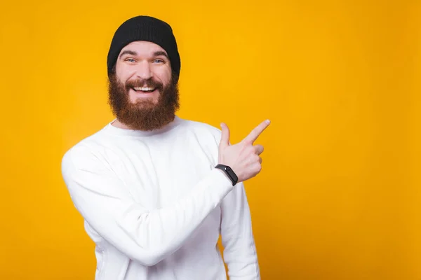 Radosny szczęśliwy człowiek z brodą wskazującą na copyspace — Zdjęcie stockowe