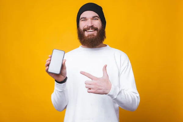 Feliz joven barbudo apuntando a la pantalla móvil — Foto de Stock