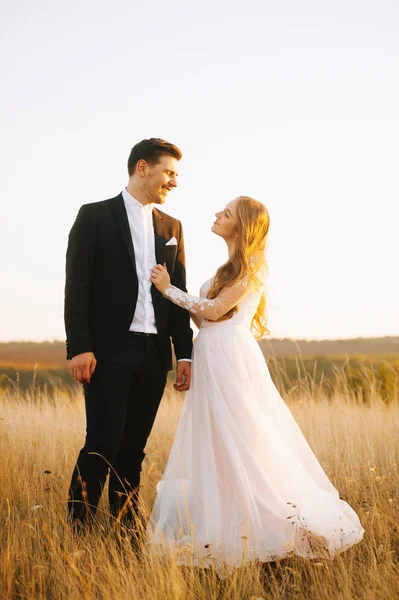 Giovane coppia felice sorride e si guarda in un campo . — Foto Stock