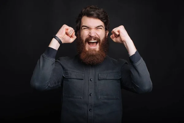 Incroyable homme barbu avec les bras levés célébrer le succès — Photo