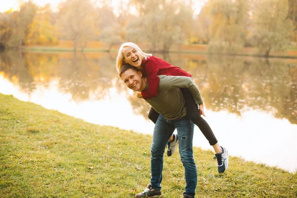 Pareja feliz divirtiéndose al aire libre durante el otoño al atardecer — Foto de Stock