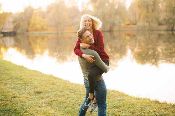 Casal feliz se divertindo ao ar livre durante o outono ao pôr do sol — Fotografia de Stock