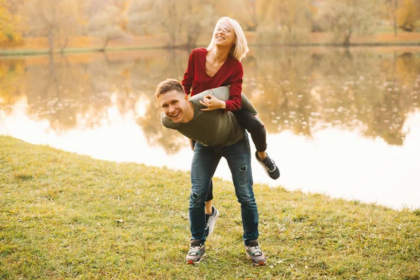 Pareja feliz divirtiéndose al aire libre durante el otoño al atardecer — Foto de Stock