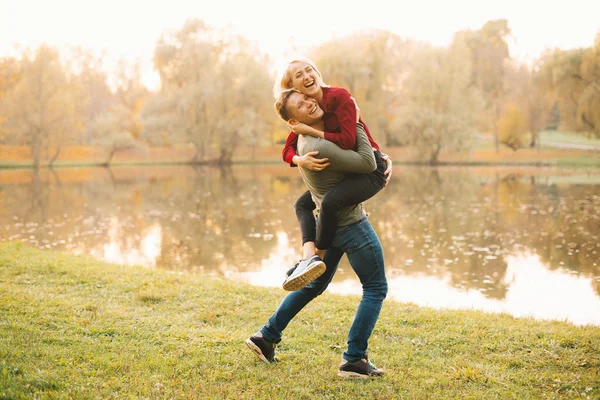 Pareja feliz divirtiéndose al aire libre durante el otoño al atardecer — Foto de Stock