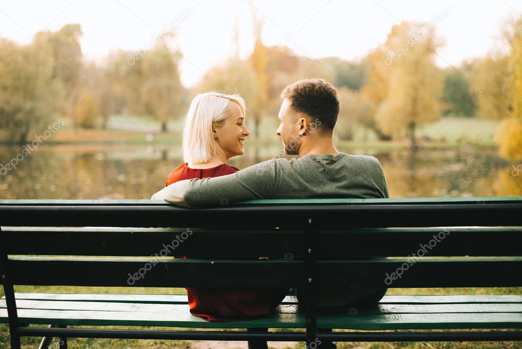 Photo of young couple sitting on bench