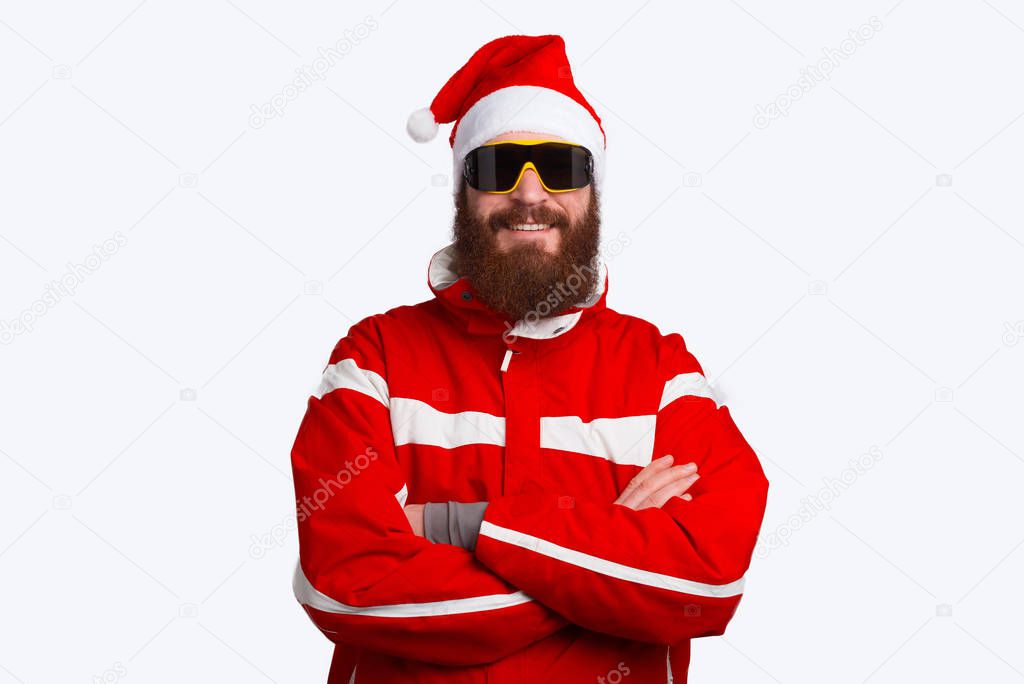 Portrait of smiling bearded man, climber wearing santa claus hat