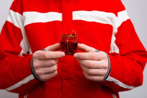 Feche a foto do homem na roupa de inverno que mantém o pequeno presente — Fotografia de Stock