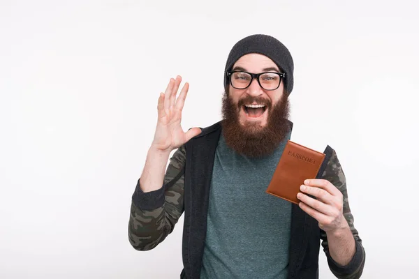 Foto des erstaunten jungen bärtigen Mannes mit Pass und Fahrkarte, Zeit für die Reise — Stockfoto