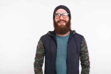 Beyaz arka planda duran genç sakallı hippi portresi.