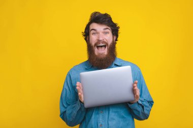 Amazed bearded man just received his new laptop