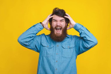 Photo of man in blue shirt screaming over yellow background