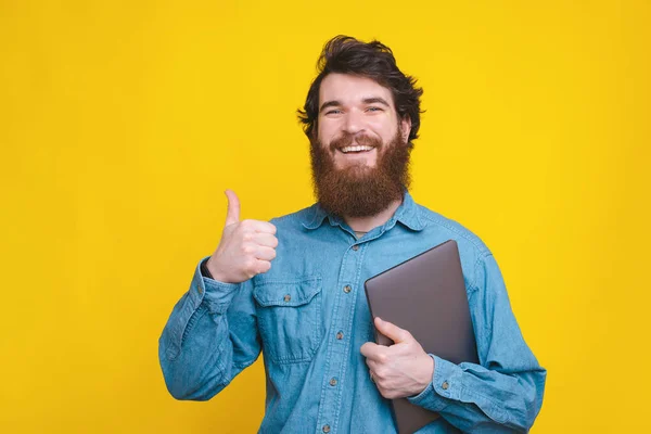 Foto eines glücklichen Arbeiters, der Daumen nach oben zeigt und Laptop hält — Stockfoto