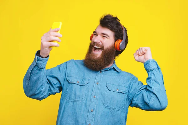 Joven feliz usando auriculares y escuchando música —  Fotos de Stock