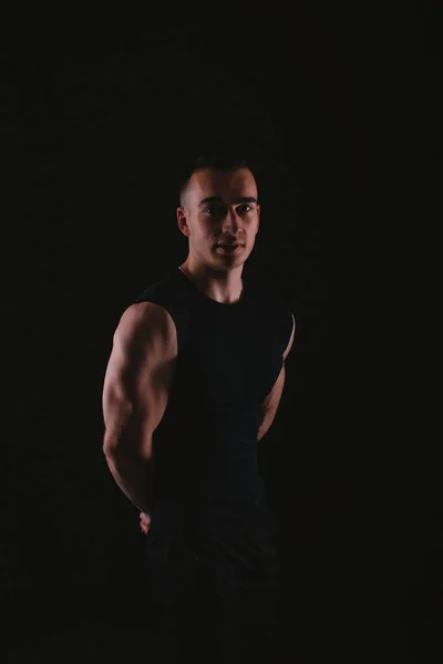 Portrait of young fitness trainer standing over dark background — 스톡 사진