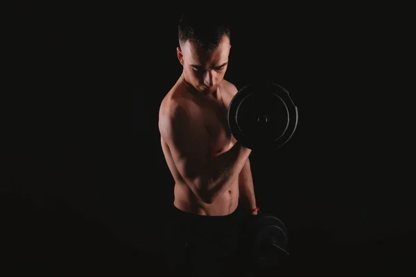 Fotografie mladého muže pracujícího na svých bicepsech s činkami — Stock fotografie