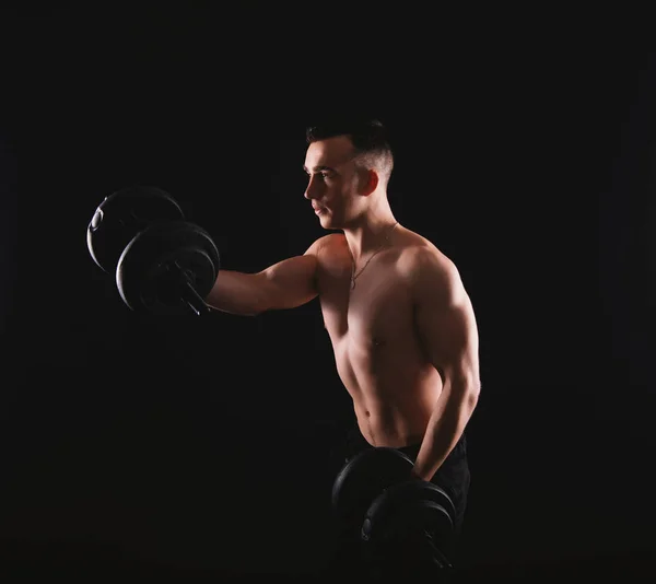 Photo of young man working at his biceps with dumbbells — 스톡 사진