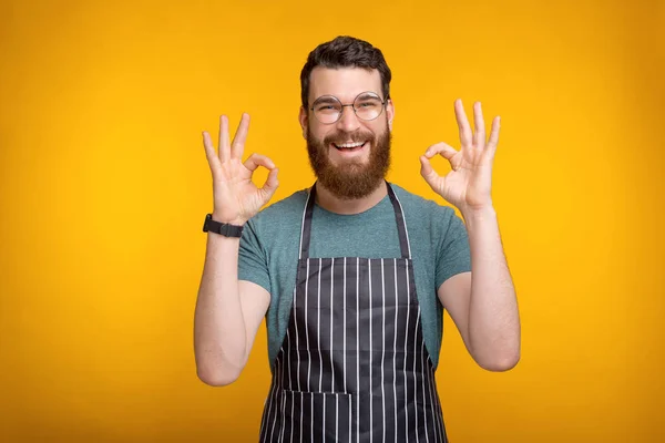 Фото веселого молодого шеф-повара в форме, показывающего жест ОК — стоковое фото