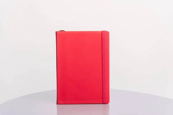 Rotes Buch, Agenda oder Planer auf grauer Fläche und weißem Hintergrund. Buchvorlage. — Stockfoto
