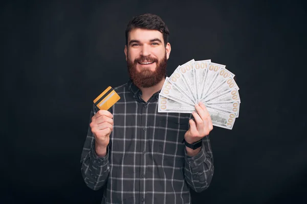 持有黄色信用卡和钱的快乐男人的画像 — 图库照片