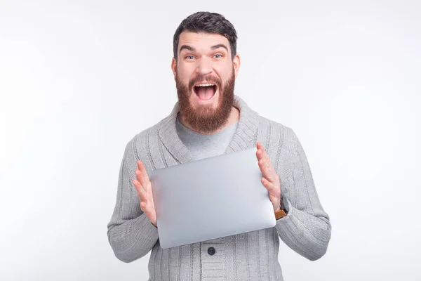 Mira, tengo un portátil nuevo. Emocionado hombre está sosteniendo y mostrando su computadora . — Foto de Stock