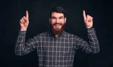 Yukarı bak. Gülümseyen bir erkek tişört giyiyor..