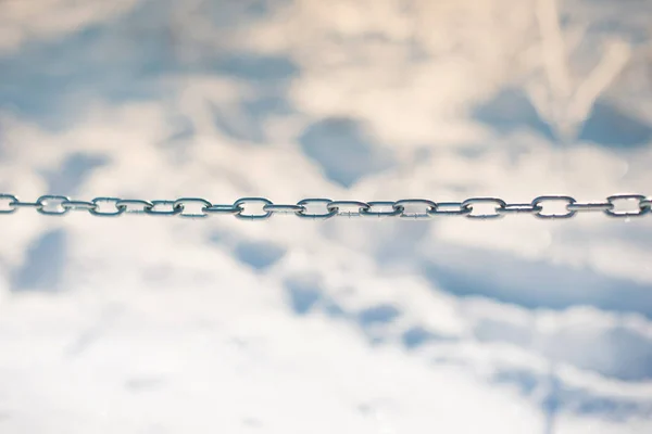 Do not enter or we are more powerful together. Photo of a chain on snowy and white background.