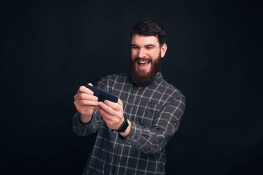 Ne harika bir oyun. Yetişkin ve sakallı bir adam telefonuyla oyun oynuyor..