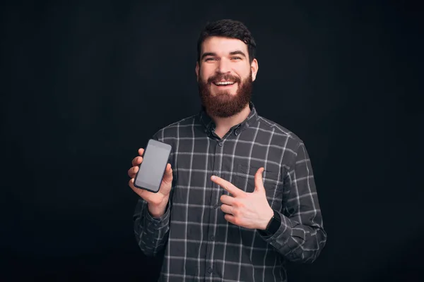 Mira mi teléfono, hay una nueva aplicación y oferta para ti. El joven barbudo señala su teléfono. . — Foto de Stock