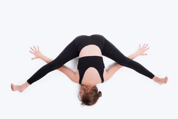 Foto einer Frau im Studio, die Yoga auf weißem Hintergrund praktiziert — Stockfoto