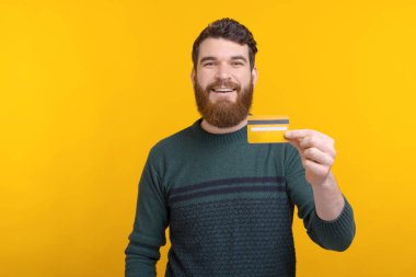 Joyful young happy man showing his credit card