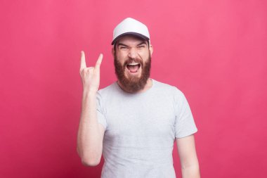 Photo of screaming young man showing rock sign