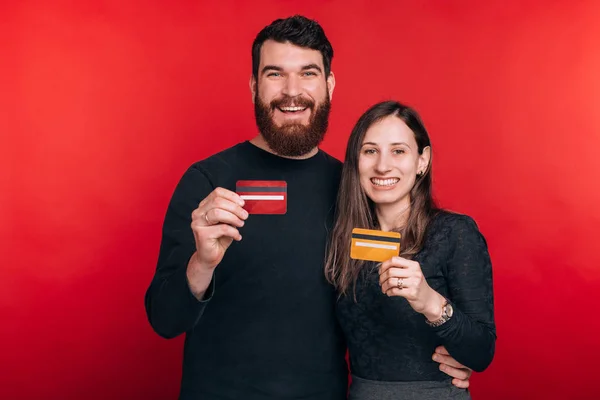 Alegre sorrindo jovem casal mostrando cartões de crédito — Fotografia de Stock