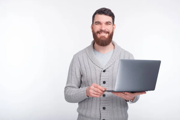 Schöner Kerl hält seinen Laptop und lächelt — Stockfoto