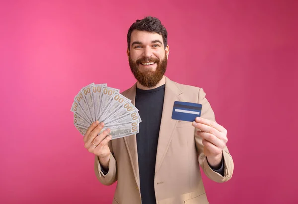 Young bearded entrepreneur is happy that he can can save his mon — Stock Photo, Image