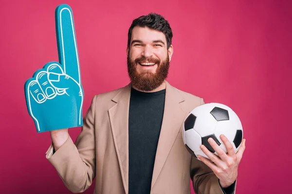 Foto de homem barbudo está segurando uma bola de futebol ou futebol e um — Fotografia de Stock