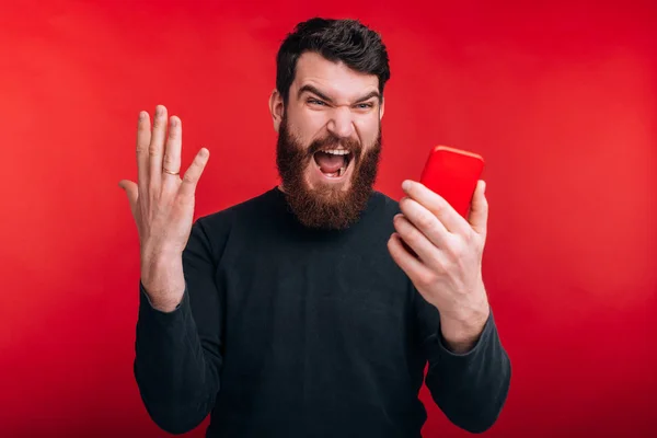 Porque é que não funciona? Zangado barbudo homem está gritando com este phon — Fotografia de Stock