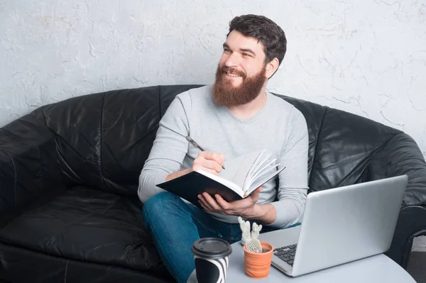 Hombre en la planificación casual de su tiempo y la escritura en la agenda —  Fotos de Stock