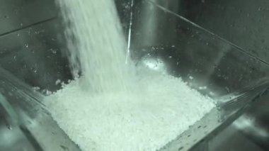 4K yakın çekim. Şef suşi için pirinç yıkıyor.