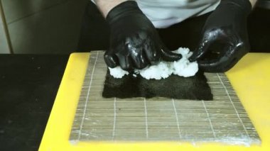 Şef iyi rulo için pilav hazırlıyor. 