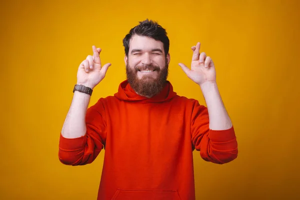 Ich wünsche mir ein neues Auto, ein Mann, der mit gedrückten Daumen über gelbem Grund steht und träumt — Stockfoto