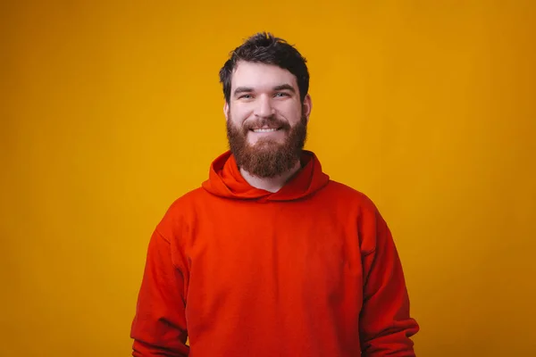 Πορτρέτο του χαμογελαστού γενειοφόρου hipster άνθρωπος με κόκκινη μπλούζα κοιτάζοντας την κάμερα — Φωτογραφία Αρχείου
