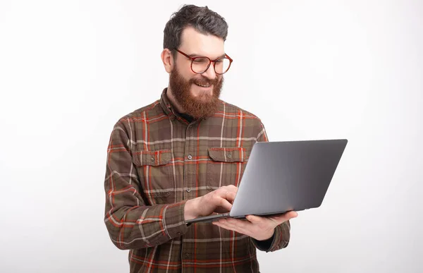 Nahaufnahme Porträt eines jungen bärtigen Mannes, der auf weißem Hintergrund im Internet sucht und surft — Stockfoto