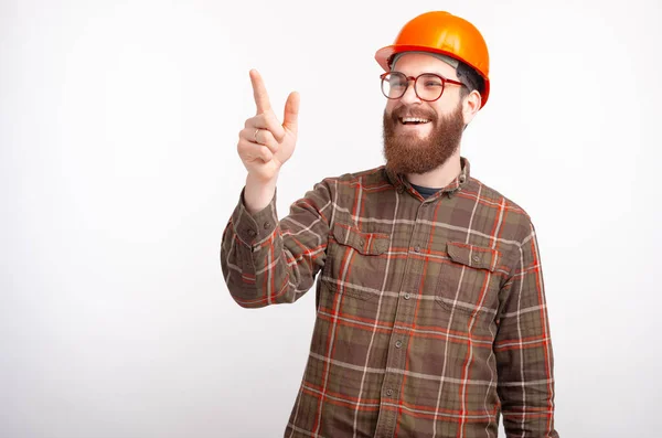 Joven ingeniero constructor barbudo o arquitecto apunta hacia adelante sobre fondo blanco — Foto de Stock