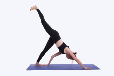 Stüdyoda beyaz arka planda yoga yapan genç bir kadın.